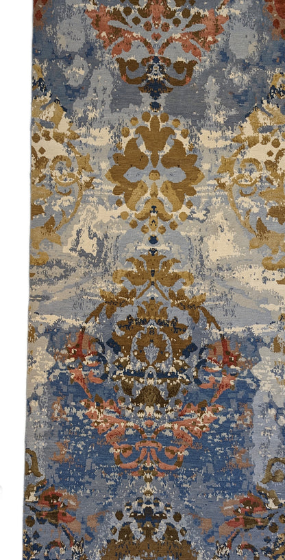 A hand-knotted rug with a luxurious blend of knots, featuring a palette of blues, salmon, ivory, brown, and gold. Wool and silk.