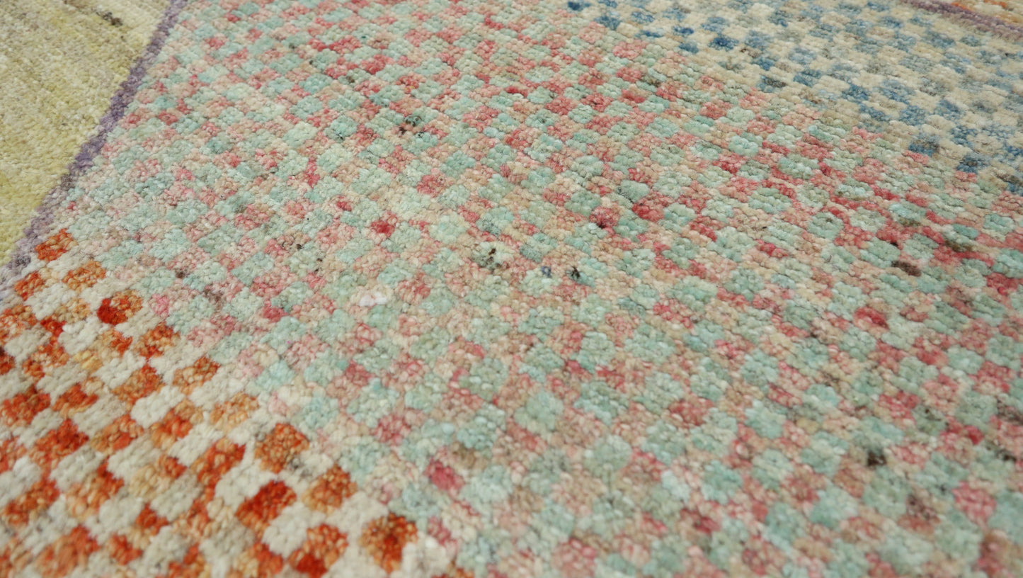 Hand-knotted geometric wool rug in sun-warmed sand and driftwood beige with hazy blue, sage green, and sunset blush accents.