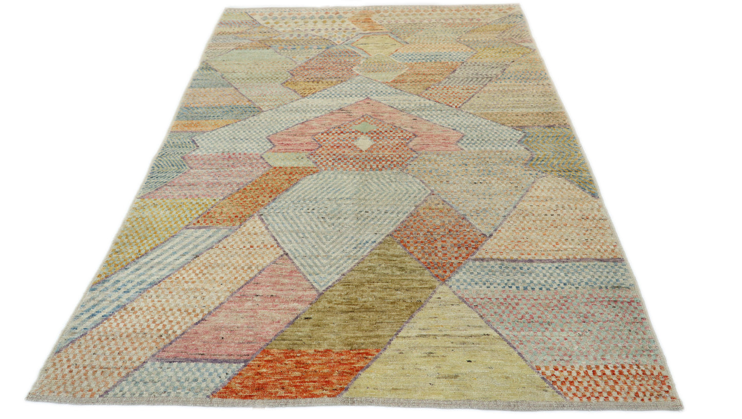 Hand-knotted geometric wool rug in sun-warmed sand and driftwood beige with hazy blue, sage green, and sunset blush accents.