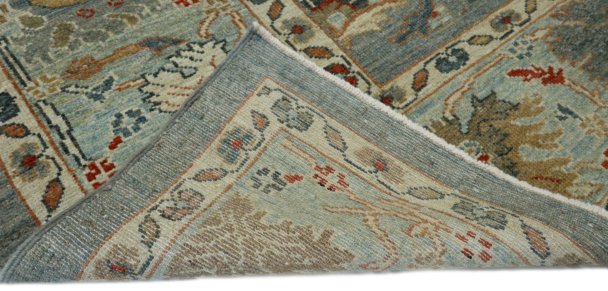 Hand-knotted wool rug with an antique finish in slate grey, red, gold, and muted coastal tones.