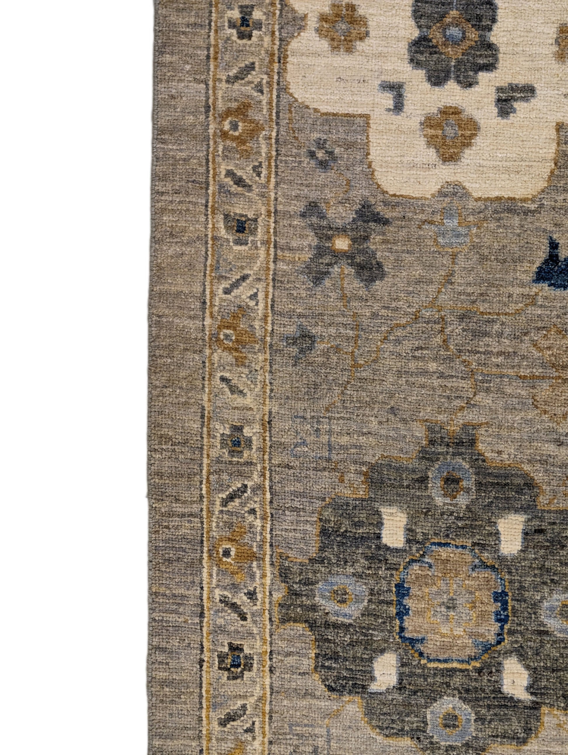A hand-knotted wool rug with a coastal design in shades of beige, blue, brown, gold, ivory, navy, and sandy grey.