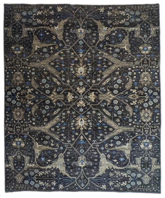A hand-knotted wool rug with a complex pattern featuring coastal hues of navy, grey, blue, and ivory, and traditional motifs.