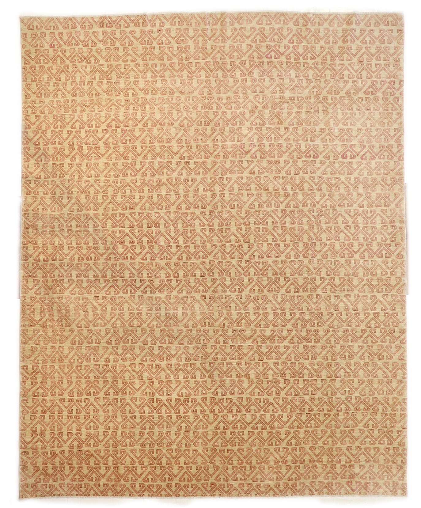 Hand-knotted sandy beige and seashell pink area rug with a subtle pattern.