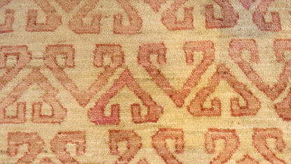 Hand-knotted sandy beige and seashell pink area rug with a subtle pattern.