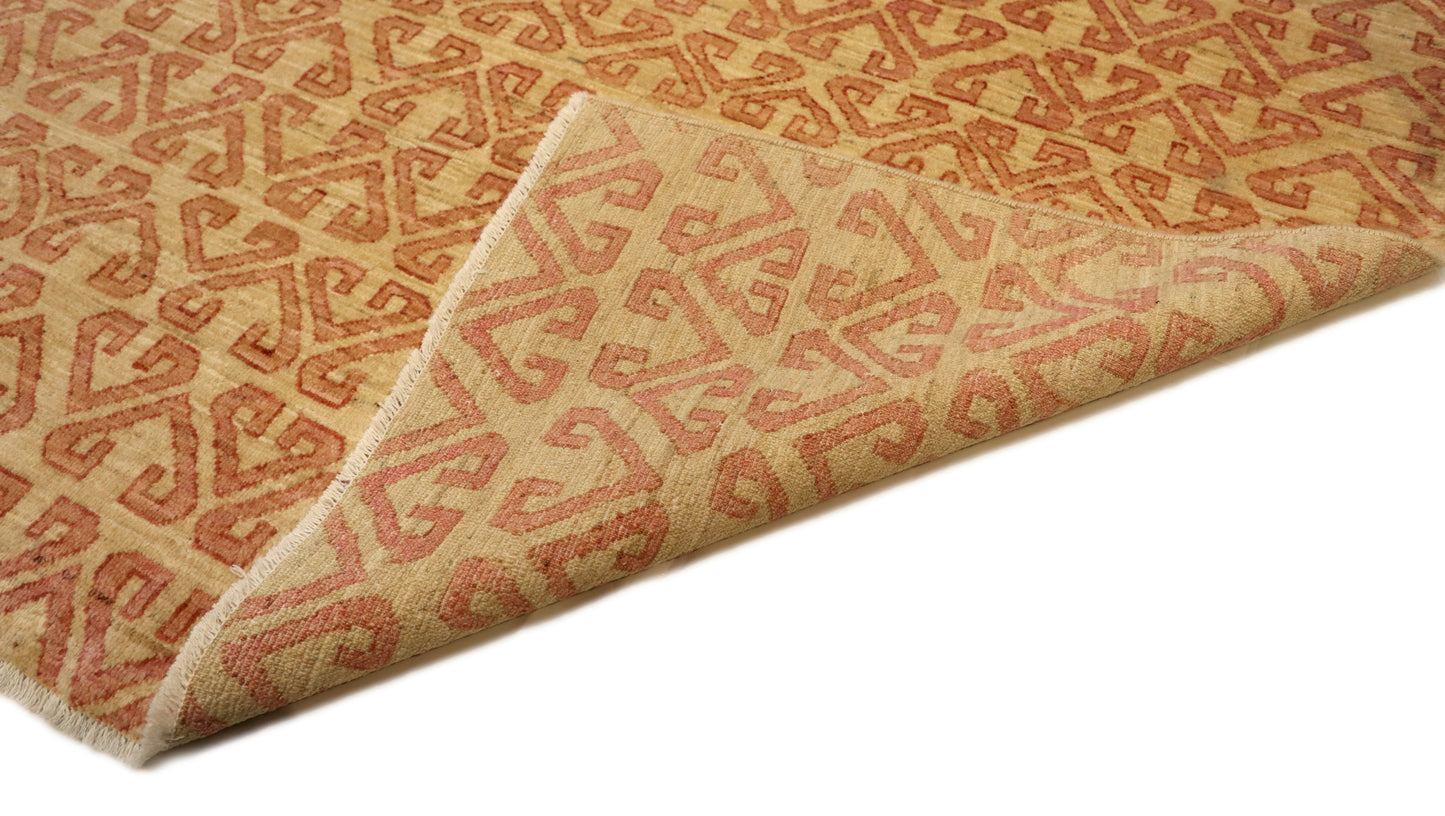 Hand-knotted sandy beige and seashell pink area rug with a subtle pattern.