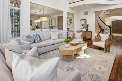 Living room with gray sectional sofa, coffee table, and decorative pillows. The space is anchored by a cozy rug that perfectly unifies the décor.