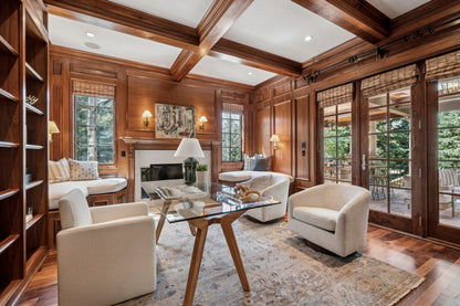 Luxurious living room with wooden beams, a fireplace, and modern furniture. The space is anchored by a cozy rug that perfectly unifies the décor.